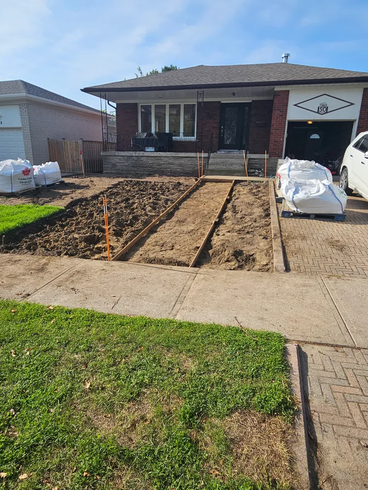 Walkway routes excavated in the front yard, with wooden forms positioned for the new paths.