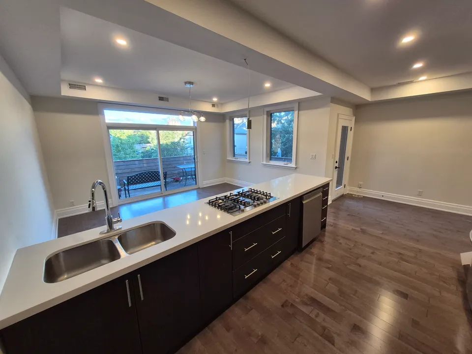 Main living space following wall and ceiling painting, with the existing kitchen island in the foreground.