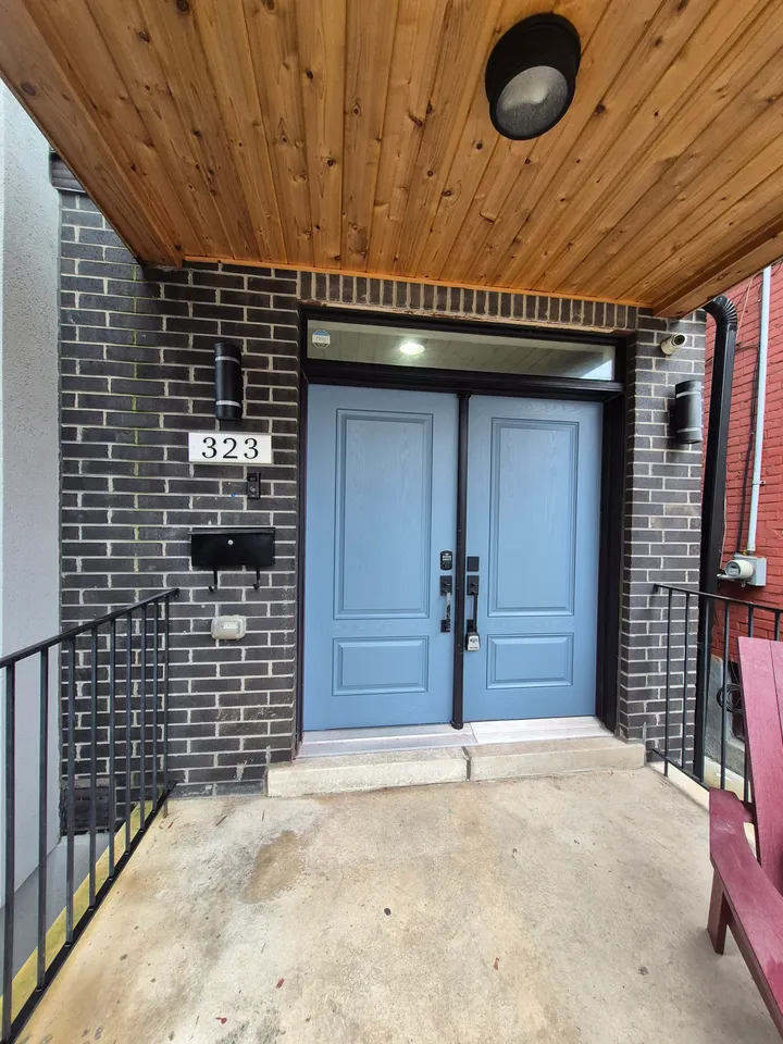 Blue-grey entrance doors with restored woodwork above the porch.