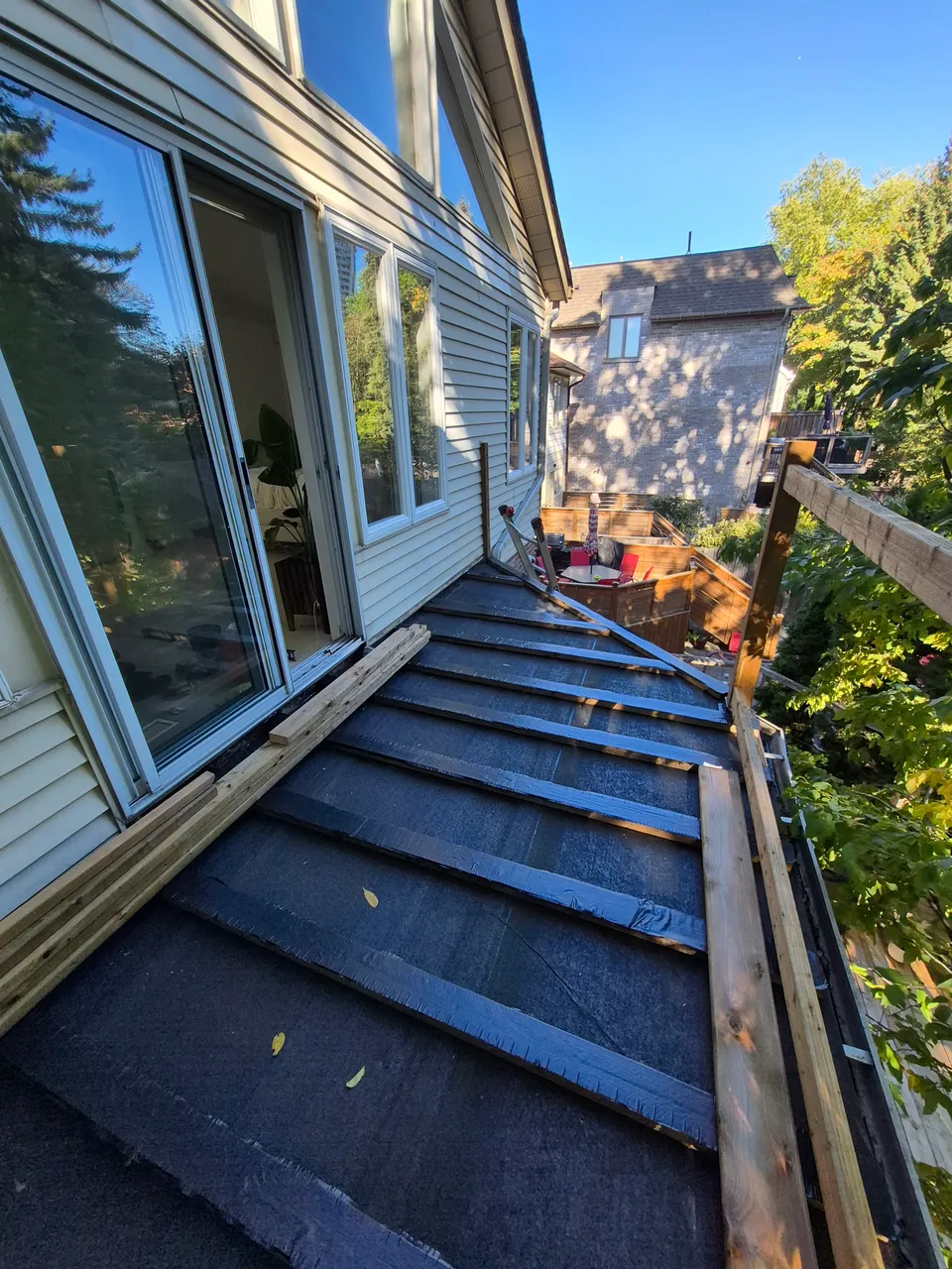 Renewed roof surface beneath exposed deck framing, before installation of the new decking.