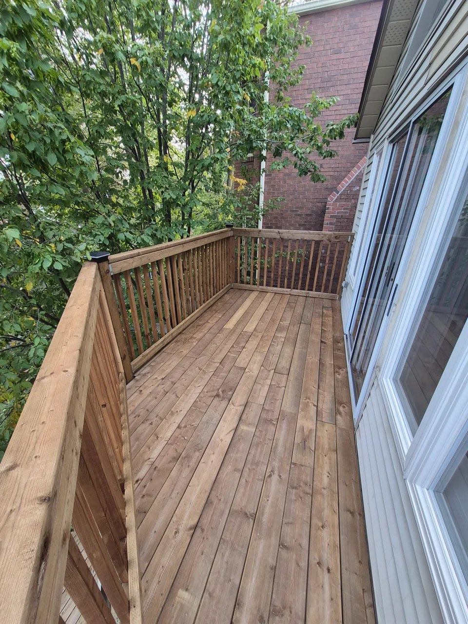 New timber deck boards and open vertical timber railings on the completed upper deck.